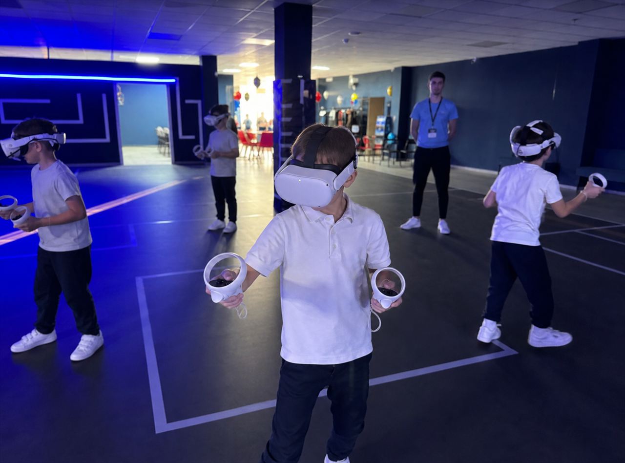 Дети играют на VR-арене в шлемах виртуальной реальности